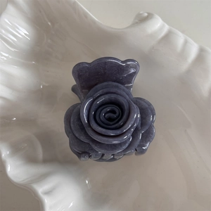 Detalle de pinza para el cabello con forma de flor violeta y textura de mármol elegante