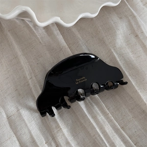 Close-up of black acetate hair claw clip with gold Barrette La France lettering