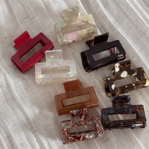 Detail of 8pcs rectangular acetate hair claws with marble patterns and gold logo