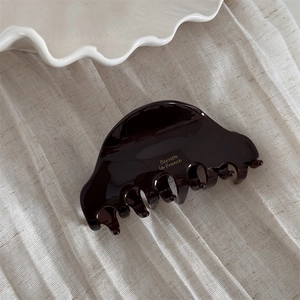 Close-up of tortoiseshell acetate hair claw with golden Barrette la France logo engraving