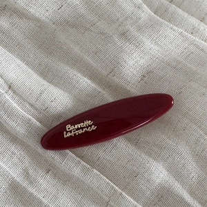 Detailed close-up of dark red hair clip with golden Barrette La France lettering