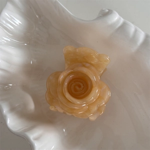 Vista macro detallada de la pinza para el pelo con flor de acetato amarillo perlado