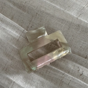 Detail showing marble textured acetate hair claw with France handmade engraving