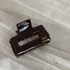 Detail of high-gloss tortoiseshell hair claw showing gold handmade France lettering