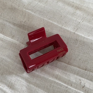 Detailed close-up of a glossy wine red rectangular hair claw with gold FRANCE handmade text