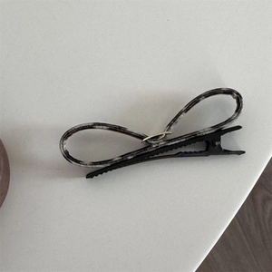 Detailed macro view of a minimalist hair clip with black and white marble pattern decor