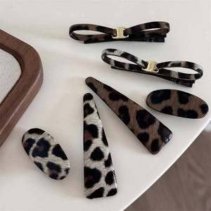 Close-up of leopard print hair clip set with smile metal decor on white background