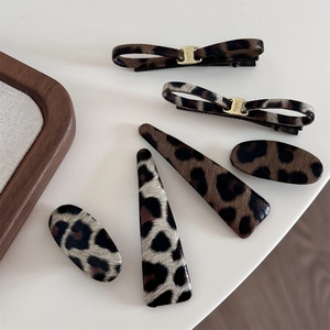 Close-up of five leopard print hair clips with leather texture and Smile metal buckle