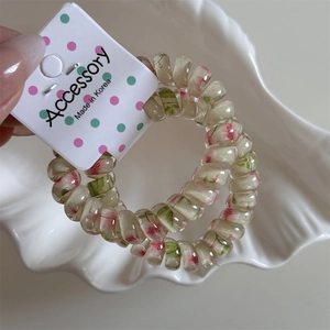 Close-up of pink floral pattern inside two elastic spiral telephone wire hair rings