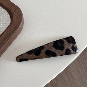 Close-up of leopard print leather hair clip with a classic triangle water drop shape design