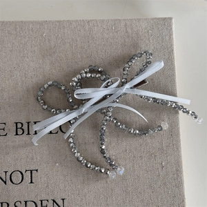 Close-up of French vintage beaded bow hair clip with gray beads and white ribbon detail
