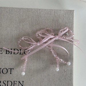 Detail view of handmade pink crystal bead bow hair clip with pearls and ribbon