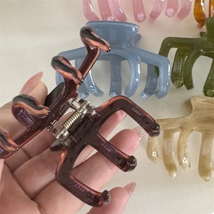 Detailed macro view of jelly-colored acetate hair claw clips with metal spring