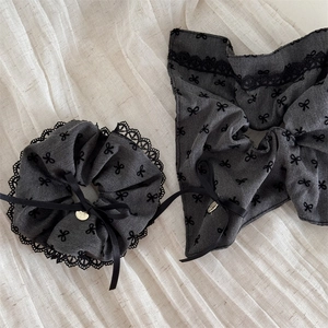 Detail of dark grey denim hair scrunchie with lace trim and golden heart charm pendant