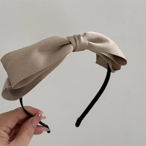 Dettaglio dell'elegante cerchietto in raso champagne con doppio fiocco raffinato