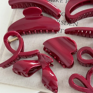 Elegant deep red glossy hair claw clip set with golden shimmer and various geometric shapes