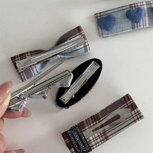 Close-up of handmade blue plaid hair clips with fabric texture and metal alligator base