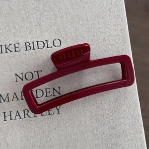 Detail view of a luxury rectangular wine red hair claw clip with a glossy finish
