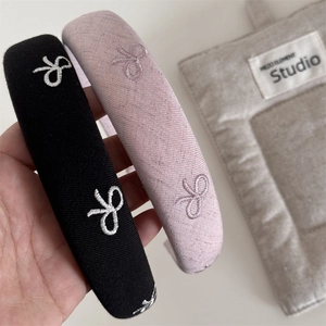 Close-up of black and pink fabric headbands with elegant butterfly embroidery details