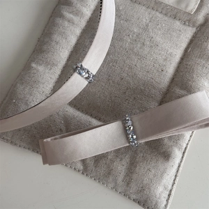 Detailaufnahme des Champagner-Satin-Hairreifs mit funkelnden Strasssteinen und Verzierung