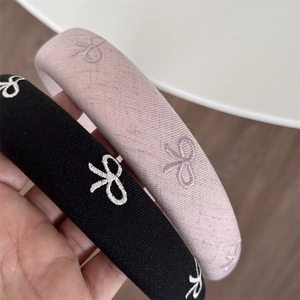 Detailed close-up of thickened sponge headbands with butterfly embroidery in black and purple