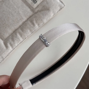 Nahaufnahme des champagnerfarbenen Satin-Haarreifs mit Strass-Schnalle und Anti-Rutsch-Zähnen