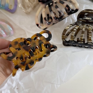 Detailed close-up of tortoise shell pattern acetate shell hair claw clip with smooth finish