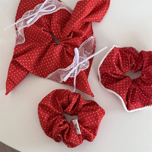 Détail de chouchous rouges à pois avec bordures en dentelle blanche et nœuds