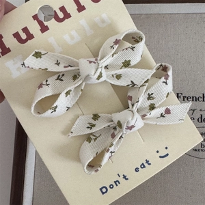 Detalle de pinzas para el cabello con lazo de tela floral en tarjeta de exhibición