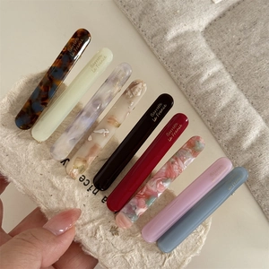 Set of 8 French acetate hair clips in assorted colors with gold lettering on cards