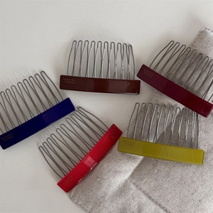 Close-up of five colorful acetate hair side combs with handmade text and 12 metal teeth