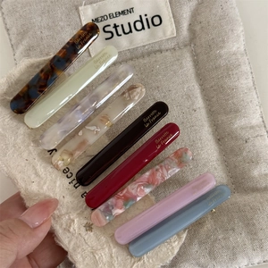Set of 9 French acetate hair barrettes in various marble and solid colors on linen pouch