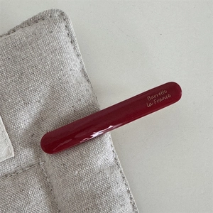 Detail of glossy deep red acetate barrette featuring elegant Barrette la France script lettering