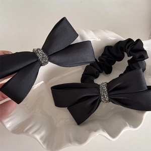 Ensemble de pinces à cheveux nuds en satin noir avec strass sur plateau en coquillage