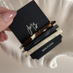 Close-up of three acetate hair clips in tortoiseshell and marble on a display card