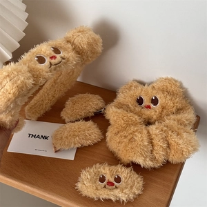 Detail view of plush honey bear hair accessories set including clips and hair tie