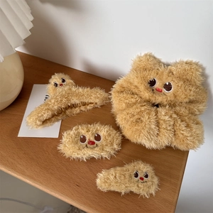 Brown plush hair accessory set with cartoon embroidery on wooden tabletop