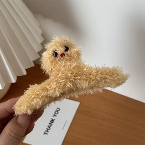 Detail of plush yellow chick hair claw clip showing soft faux fur and embroidered features