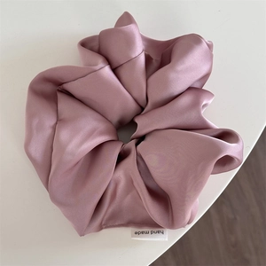 Detail of premium satin oversized scrunchie in dusty rose with hand made label
