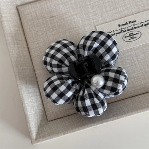 Close-up of black and white plaid fabric flower hair claw clip with a center pearl