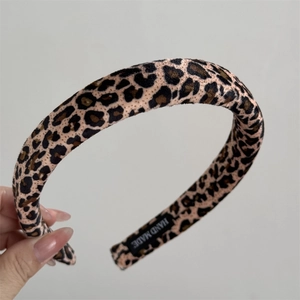 Close-up of leopard print velvet headband featuring a woven Hand Made fabric label