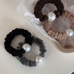Set of four shimmering fabric hair scrunchies with large pearls in metallic neutral colors