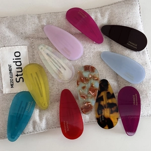 Set of 10 colorful acetate water drop hair clips displayed on beige fabric bag