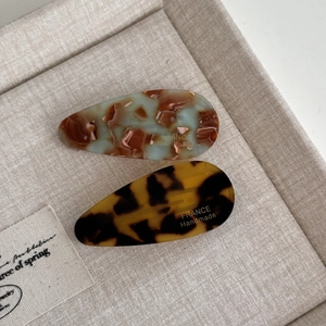Detail of handmade acetate water drop hair clips with mint green and tortoiseshell patterns