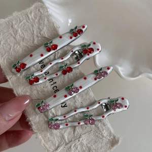 Detail of four-piece cherry hair clips set with polka dots and red crystal rhinestones