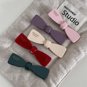 Cinq barrettes à nœuds en acétate de couleurs variées dans une disposition stylée