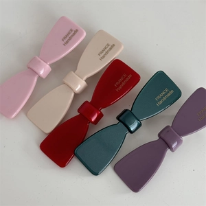 Détails des barrettes nœuds en acétate coloré avec inscription dorée faite à la main