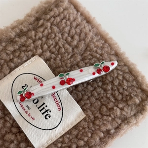 Detailed macro view of cherry hair clip with red rhinestones and polka dots on alloy