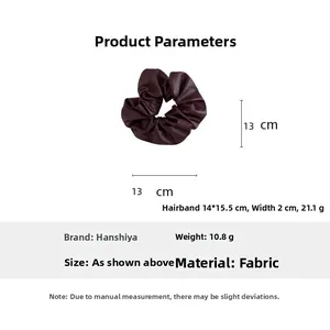 Macro view of burgundy faux leather scrunchie showing 13cm diameter and 10.8g weight detail