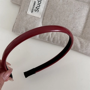 Détail d'un serre-tête rouge foncé brillant avec doublure antidérapante et laque